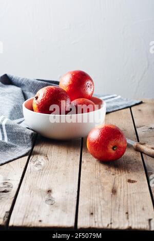 Frische rote Blutorangen in einer Schüssel auf einem Holztisch. Stockfoto