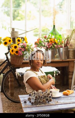 Portrait zuversichtlich weibliche Floristin unter Kaffeepause im Blumenladen Stockfoto