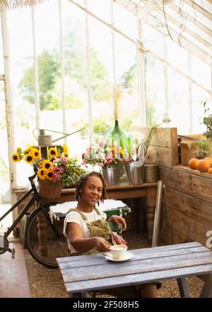 Portrait weibliche Bäcker genießen Kaffeepause im Blumenladen Stockfoto