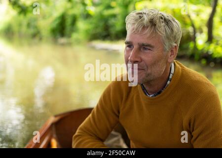 Glücklicher Mann im Boot auf dem Fluss Stockfoto