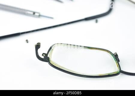 Gebrochene Brillen auf grauem Hintergrund. Brillen Reparaturkonzept. Stockfoto