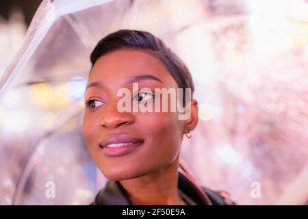 Close up schöne junge Frau mit kurzen schwarzen Haaren unter Regenschirm Stockfoto