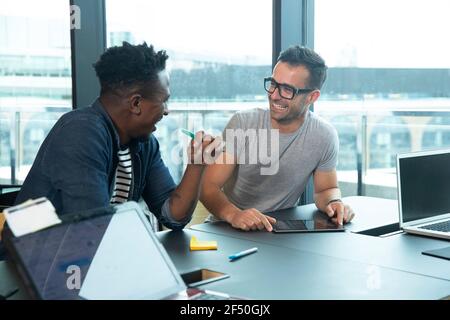 Glückliche Geschäftsleute mit digitalen Tablet-Meeting im Büro Stockfoto