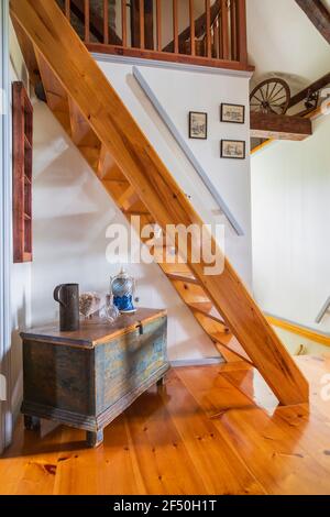 Antiker hölzerner Chest Tisch mit Vintage-Objekten unter Kiefernholz Miller's Treppe führt zum Dachgeschoss Zimmer von oben Flur mit Pinewood-Boden Stockfoto