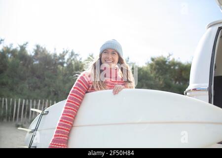 Portrait glücklich junge Surferin mit Surfbrett Stockfoto