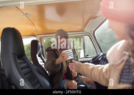 Glückliche junge Freundinnen genießen Kaffee im Wohnmobil Stockfoto