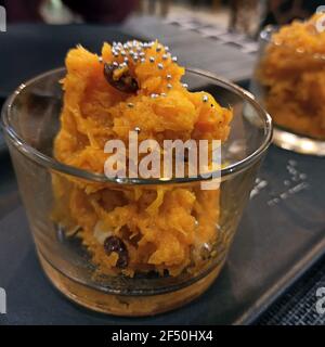 Gajar ka Halwa (Oder Gajrela)-das indische Erbe ‘Saffron Delight’ Karotten Pudding serviert mit Die Toppings von trockenen Früchten serviert in einer transparenten Tasse ma Stockfoto