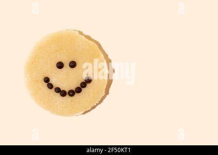Lächelndes Gesicht Schokolade Chip Cookie Teig auf gelbem Hintergrund in hellem Licht, die Freude am Kochen, Nahaufnahme. Stockfoto