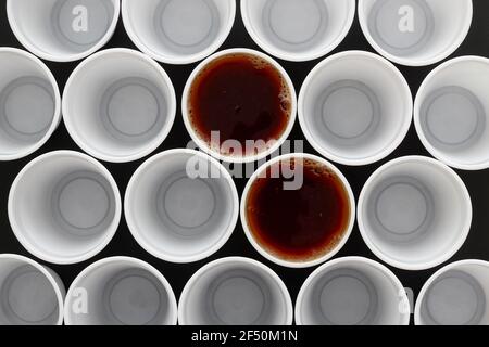 Zwei schwarze Tee in Kunststoff Einwegbecher zusammen mit vielen anderen Tassen, Blick von oben. Stockfoto