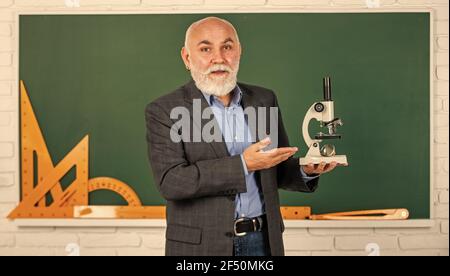 Entdecken Heilung. Wissenschaft Experimente im Labor. Biologie Schule Laborausrüstung. Mann im Klassenzimmer mit mathematischen Werkzeugen an der Tafel. Senior Lehrer verwenden Stockfoto