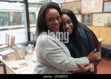 Portrait glückliche Mutter und Tochter umarmt im Restaurant Stockfoto