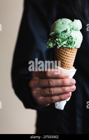 Frau hält Waffel Eis Kegel mit einer Kugel Eis gekrönt. Stockfoto
