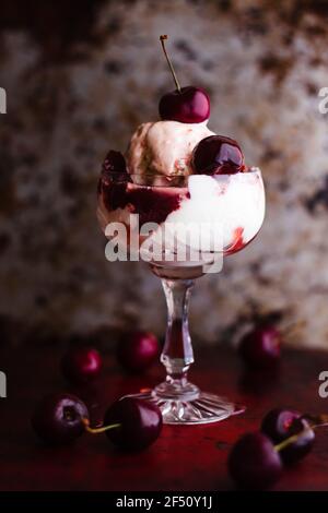 Ein eissonntag in einem Coupé-Glas mit Kirschen gekrönt. Stockfoto