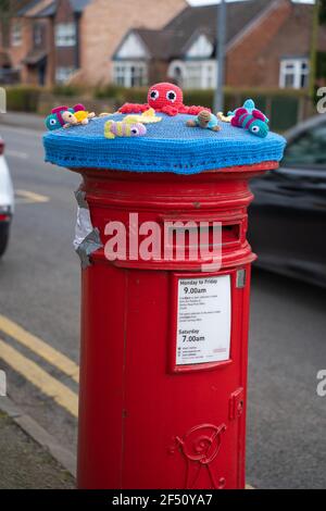 Rot, Briefkasten, Briefkasten, gehäkelt, Royal Mail, Wollmützen, Abdeckungen, handgestrickt, Säulenboxen, Lincoln City, Meerestiere, Osterhasen, Blumen. Stockfoto