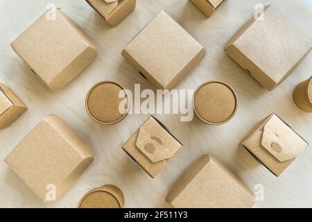 Flache Lay von verschiedenen dispasable Pappschachteln und Tassen auf Holzstruktur. Stockfoto