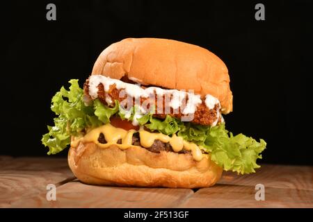 Ein Hamburger (kurz Burger) ist ein Sandwich, das aus einem oder mehreren gekochten Hacksteaks, in der Regel Rindfleisch, in ein geschnittenes Brot gelegt wird Stockfoto