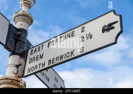 Ein alter Metallweg-Wegweiser in Athelstaneford, der in Richtung Drem und North Berwick zeigt. Stockfoto