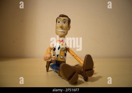 Avola, Sizilien - März 21st 2021: Nahaufnahme von Woody aus dem beliebten Actionfilm Toy Story, über einem Holztisch sitzend und lächelnd. Stockfoto