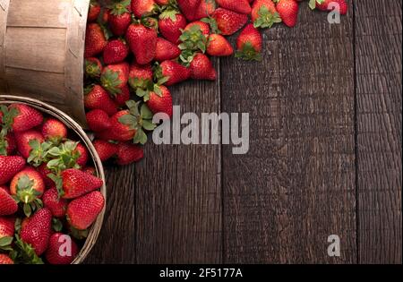 Eimer mit Erdbeeren auf dem Holzboden mit Kopierplatz Stockfoto