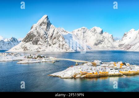 Luftaufnahme Winter Blick auf Sakrisoy Dorf und verschneite Berge im Hintergrund. Beliebtes Touristenziel auf Lofotens. Ort: Sakrisoy , Moskenesoya Stockfoto