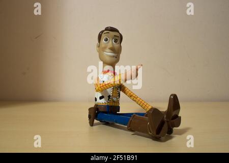 Avola, Sizilien - März 21st 2021: Nahaufnahme von Woody aus dem beliebten Actionfilm Toy Story, über einem Holztisch sitzend und lächelnd. Stockfoto