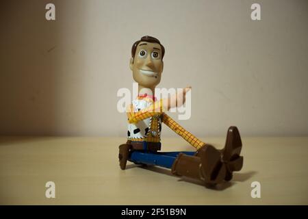 Avola, Sizilien - März 21st 2021: Nahaufnahme von Woody aus dem beliebten Actionfilm Toy Story, über einem Holztisch sitzend und lächelnd. Stockfoto