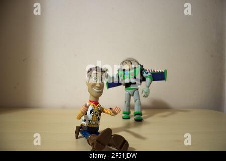 Avola, Sizilien - März 21st 2021: Sheriff Woody und Buzz Lightyear Toys, Figuren aus Toy Story, die dicht beieinander auf einem Holztisch liegen. Stockfoto