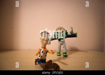 Avola, Sizilien - März 21st 2021: Sheriff Woody und Buzz Lightyear Toys, Figuren aus Toy Story, die dicht beieinander auf einem Holztisch liegen. Stockfoto