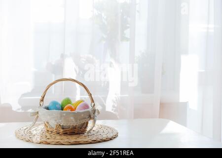 Ostern bunte Eier in busket auf weißem Holztisch. Frohe Ostern Hintergrund mit Copyspace. Stockfoto