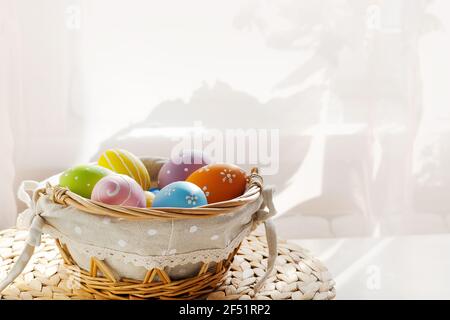 Ostern bunte Eier in busket auf weißem Holztisch. Frohe Ostern Hintergrund. Stockfoto