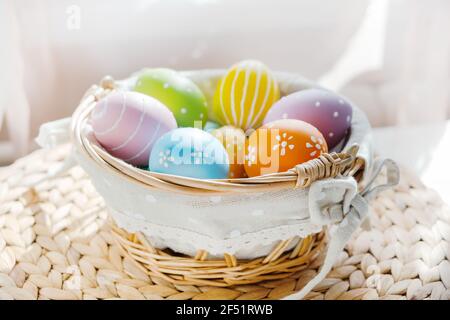 Ostern bunte Eier in busket auf weißem Holztisch. Frohe Ostern Hintergrund. Stockfoto