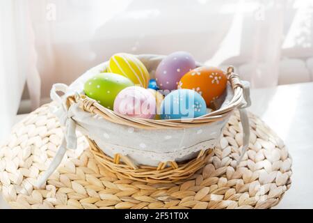 Ostern bunte Eier in busket auf weißem Holztisch. Frohe Ostern Hintergrund. Stockfoto