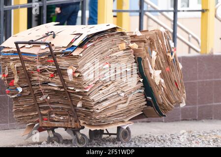 Ein Hausmeister-Wagen mit verpackter Pappe. Hausmeister sammeln Karton für die spätere Anlieferung in Altpapier. Stockfoto