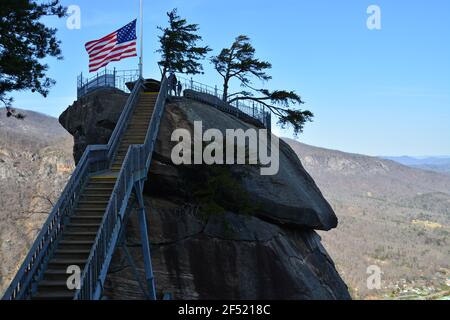 Die amerikanische Flagge weht auf dem namensgebenden Granitturm im Chimney Rock State Park außerhalb von Asheville, North Carolina. Stockfoto