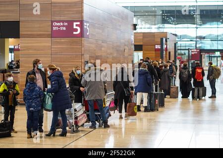 Berlin, Deutschland. März 2021, 23rd. Am 23. März 2021 warten Passagiere auf den Check-in am Flughafen Berlin Brandenburg in Schönefeld. Deutschland werde seine COVID-19-Sperre bis mindestens April 18 mit noch strengeren Einschränkungen während der Osterferien verlängern, kündigte Bundeskanzlerin Angela Merkel in den frühen Morgenstunden des Dienstags auf einer Pressekonferenz an. Quelle: Stefan Zeitz/Xinhua/Alamy Live News Stockfoto