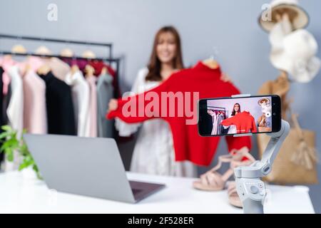 Junge Frau verkauft Kleidung online per Smartphone Live-Streaming, Geschäft Online-E-Commerce zu Hause Stockfoto