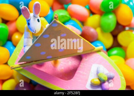 Kleiner Holzhase, der auf Gelee-Bohnen ruht Stockfoto