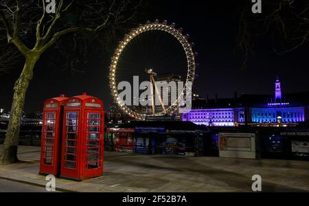 London, Großbritannien. März 2020, 23rd. Das Foto vom 23. März 2021 zeigt das London Eye in gelber Beleuchtung in London, Großbritannien. Großbritannien hat am Dienstag ein Jahr seit der ersten Blockierung des Coronavirus im Land durch den britischen Premierminister Boris Johnson im vergangenen Jahr angekündigt. Am 23. März 2020 stellte Johnson Maßnahmen vor, um die Ausbreitung von COVID-19 zu stoppen. Eine nationale Schweigeminute fand am Mittag als Teil eines Tages der Reflexion statt. Die Briten werden auch ermutigt, um 2000 Uhr MEZ mit Telefonen, Kerzen und Fackeln an das vergangene Jahr zu erinnern. Quelle: Han Yan/Xinhua/Alamy Live News Stockfoto