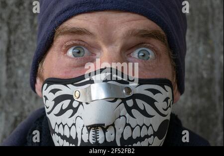 Blaue Augen Junge trägt Maske, verspielte Optik. Überrascht Stockfoto