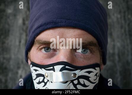 Blaue Augen Junge trägt Maske, ernst aussehen Stockfoto