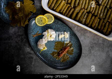 Draufsicht, Zubereitung von gefüllten Traubenblättern mit dem Namen Dolma , hergestellt aus Reben mit Reis, Fleisch und Gewürzen. Stockfoto