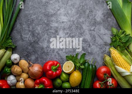 Ein Mix aus verschiedenen Gemüsesorten auf dem Tisch und in der Mitte ein leerer Schreibraum.Kochkonzept. Stockfoto