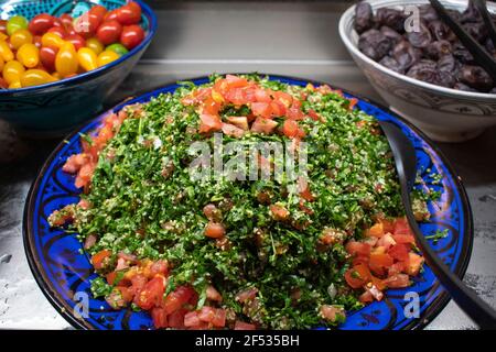 Tabbouleh Arabisch auch Tabbouleh. Salat aus meist fein gehackter Petersilie, mit Tomaten, Minze, Zwiebel, Bulgur Stockfoto