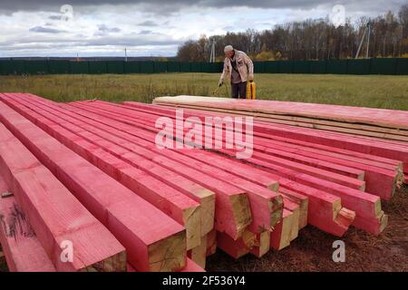 Kaluga, Russland 15. Oktober 2019: Bauarbeiten, ein Arbeiter malt Holzbalken mit einer speziellen Lösung. Neu Stockfoto