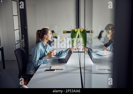 Weibliche Angestellte las ihre Memos während der Kaffeepause Stockfoto