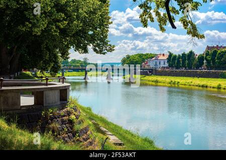 Ufer der uzh. Wunderschöne Stadtkulisse im Sommer. Blick unter dem Schatten einer Lindenzweige. Brücke in der Ferne Stockfoto