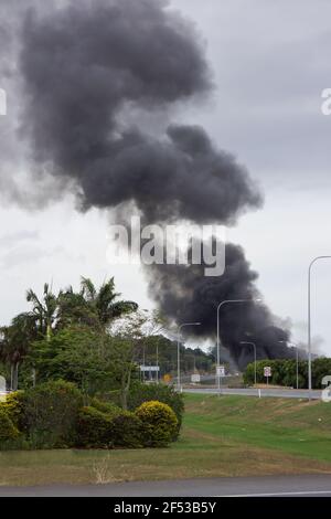 Eine große schwarze Rauchwolke von einem Gebäude auf Feuer, das sich in der Nähe der Autobahn befindet. Stockfoto