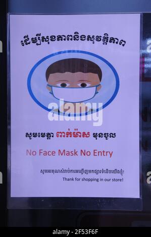 Ein zweisprachiges COVID - 19 Warnschild "No Face Mask, No Entry" am Eingang zu einem Lebensmittelgeschäft während der Coronavirus-Pandemie. Steung Meanchey, Phnom Penh, Kambodscha. © Kraig Lieb Stockfoto