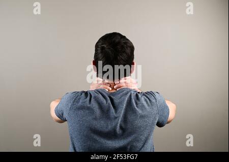 Rückansicht des Mannes mit Nackenschmerzen. Gesundheitsproblem bei der Büroarbeit. Hochwertige Fotos Stockfoto