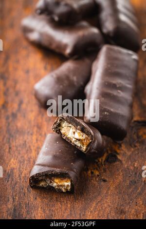 Schokoriegel mit Nußfüllung auf Holztisch. Stockfoto